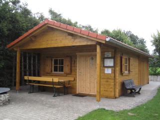 Vereinsheim aus Blockbohlenbauweise mit Vordachbereich für die Biergarnitur