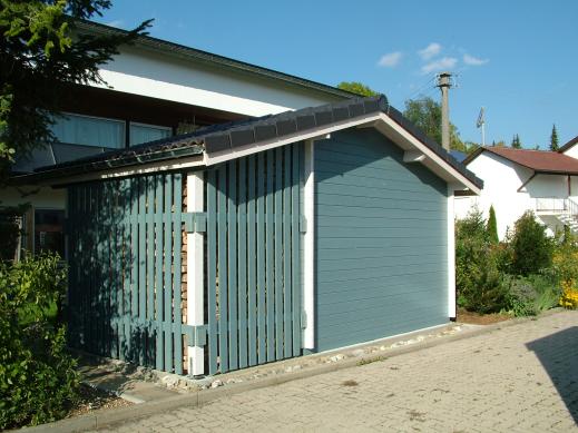 Blaues Gerätehaus mit Satteldach samt integriertem Holzlager in einem Wohngebiet