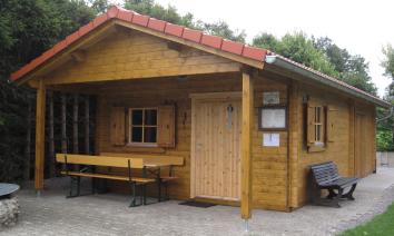 Vereinsheim aus Blockbohlenbauweise mit Vordachbereich für die Biergarnitur